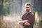 Handsome fit man posing in forest wearing checked shirt