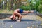 Handsome flexible Athletic man doing yoga asanas in the park