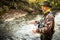 Handsome fly fisherman  fly fishing on a splendid mountain river for rainbow trout
