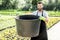 Handsome gardener with huge bucket