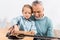 handsome grandfather playing with grandson on knees playing on acoustic guitar