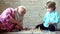 Handsome grandpa and grandson are playing chess while spending time together at home. Little boy playing chess with his