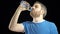 Handsome gray haired man in blue t-shirt drinking water from pastic bottle. Black background