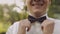 Handsome groom fixes his bow tie. Close up shot. Wedding morning. Slow motion