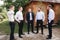 Handsome groom with his groomsman on the backyard. Five man. Groom dressed in suit, gromsmen in white shirt. Funny guys