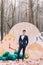 Handsome groom posing in the autumn forest. Decorative clocks on background