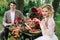 The handsome groom sit at the festive table on blurred bride background. Autumn wedding