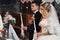 Handsome groom in suit and a beautiful blonde bride holding candles in church