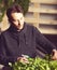 Handsome grower is watering potted plants indoor.