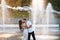 Handsome guy and beautiful girls kissing on the background of a fountain