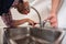 Handsome guy repair pipes on sink in the kitchen