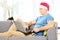 Handsome guy with santa hat on a sofa working on a laptop at home