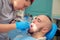 Handsome guy treats caries teeth in the dental office