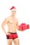 Handsome guy wearing red underpants and christmas hat holding a