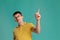 Handsome guy in a yellow casual t-shirt is posing over a blue background.