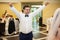 Handsome happy groom in white shirt having fun during first dance with bride at reception