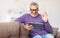Handsome happy senior man waving by hand while talking online on digital tablet with family