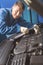 Handsome hardworking mechanic repairing a car