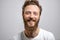 Handsome hipster man with beard smiling at camera over white background.