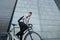 Handsome hipster man posing with bicycle in the city.