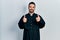 Handsome hispanic man with beard wearing catholic priest robe success sign doing positive gesture with hand, thumbs up smiling and