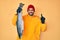 Handsome hispanic man with beard wearing fisherman equipment surprised with an idea or question pointing finger with happy face,