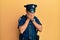 Handsome hispanic man wearing police uniform with sad expression covering face with hands while crying