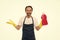 Handsome household worker. Mature man holding detergent bottle in rubber gloves. Senior man in apron ready for