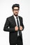 Handsome indian man in glasses standing against white background