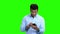 Handsome Indian man using phone on green screen.