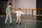 Handsome instructor holding training child on roller skates with