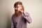 Handsome Irish redhead business man with beard wearing glasses over isolated background smiling with hand over ear listening an