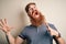 Handsome Irish redhead man with beard and arm tattoo standing over isolated background crazy and mad shouting and yelling with