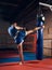 Handsome kick boxer training kicking and punching boxing bag