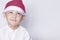 Handsome kid with Santa cap wishing or dreaming something. Child dreaming about Christmas gift. Kid looking up and thinking