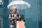 Handsome lady with mobile phone walking with umbrella, texting, hold smartphone