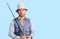 Handsome latin american young man wearing fisherman equipment thinking attitude and sober expression looking self confident