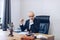 A handsome lawyer is sitting at a wooden table waiting for a contract to be signed by the customer.