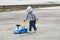 Handsome little boy in grey plays with toy car