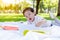 Handsome little boy is opening a book for reading and learning by himself at a park. Charming handsome kid love reading and lookin