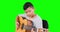 Handsome little boy playing guitar in studio