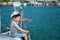 Handsome little captain boy pointing with his finger to the distance sitting on luxury yacht in summer tour