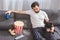 handsome loner sitting with bulldog on sofa and holding drink in living