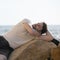 Handsome in love man outdoor portrait lying on a rocks and dreaming