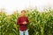 handsome male african american modern farmer and entrepreneur posing in the corn crop and smiling at camera,