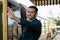 Handsome male British officer in vintage uniform at train station next to train waving and smiling