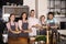 Handsome male chef with young people holding plates with prepared dishes during cooking classes