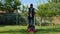 Handsome male gardener mowing grass with an electric lawn mower. Young man mows the grass in own garden with a grass