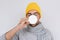 Handsome male having sore throat influenza. Portrait of sick man have virus and drinking cup of tea, wearing glasses, yellow hat,