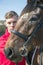 Handsome Male Horse Rider standing next to horse